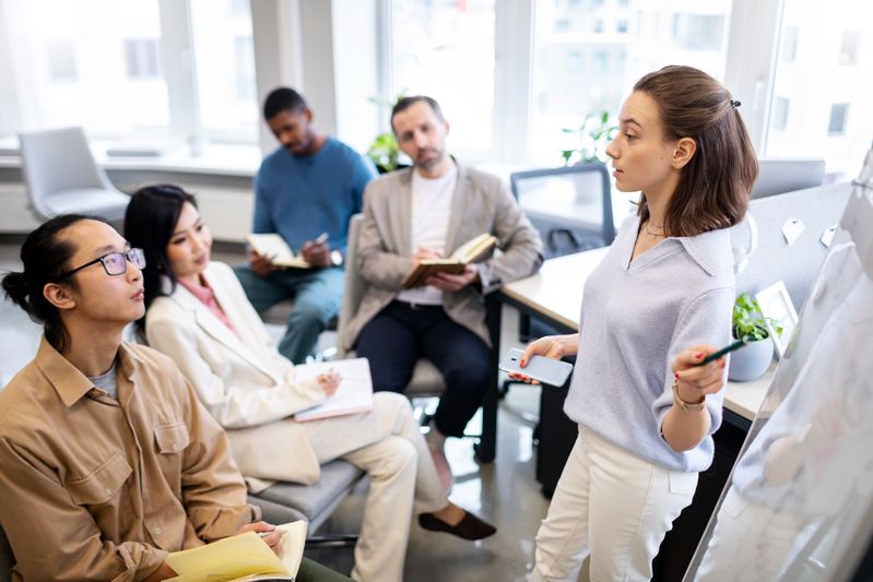 Ejecutiva explicando los diferentes tipos de coaching empresarial a sus empleados